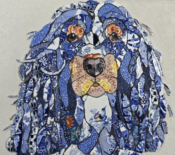 “Handmade mosaic portrait of a Cocker Spaniel created from individually hand‑cut vintage china plates in soft cream and patterned tones.”