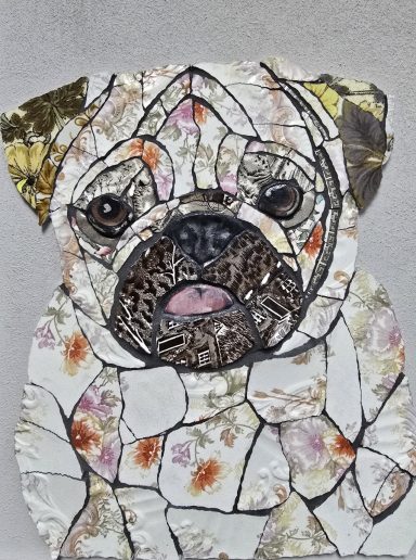 A mosaic artwork of a pug's face with various coloured tiles.