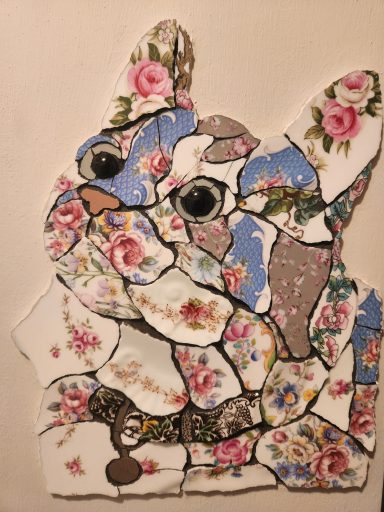 A decorative collage of a French Bulldog featuring floral patterns and vibrant colours.