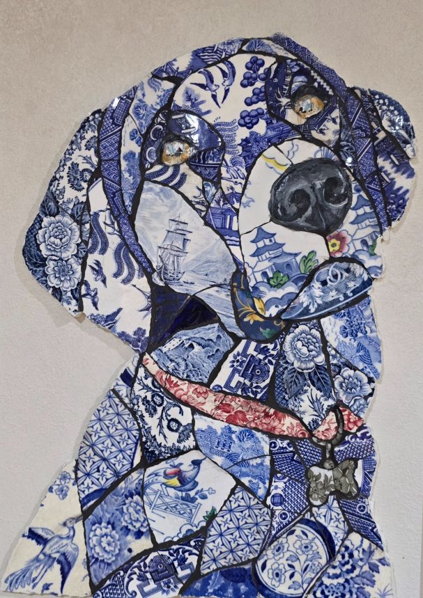 “Handmade mosaic portrait of a black Labrador created from individually hand‑cut vintage china plates in soft cream and patterned tones.”