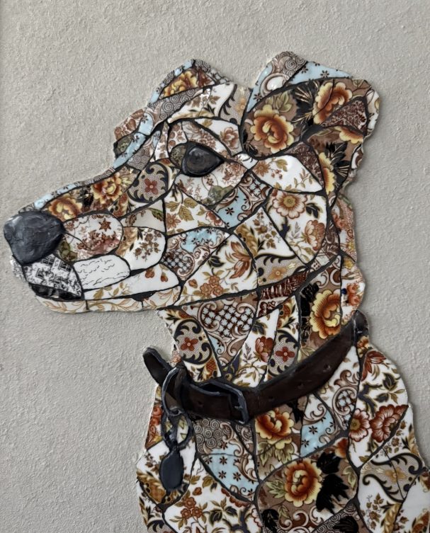 Handmade mosaic portrait of a Whippet Cross created from individually hand‑cut vintage china plates in dark and neutral tones.”