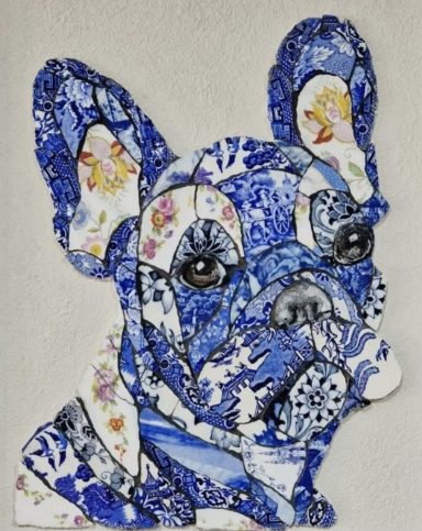 Mosaic artwork of a French Bulldog created from vintage china, featuring the dog’s signature bat-like ears and expressive face. 