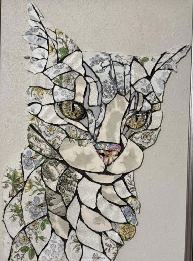 Mosaic artwork of a cat's face with intricate patterns and floral elements.